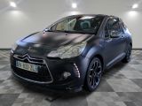 La voiture noire est garée sur le sol à damier du garage.