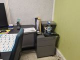 a desk with a computer monitor and a printer on it