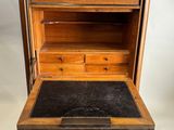 un vieux bureau en bois avec un plateau en marbre noir et des tiroirs