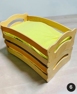 un lit en bois pour enfant sur lequel est posé un oreiller jaune