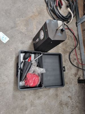 une boîte à outils posée par terre à côté d'une boîte de câbles