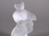 une figurine en verre transparent représentant un homme tenant un bébé dans ses bras