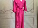 a pink dress on a mannequin stand in a room