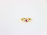 une bague en or jaune sertie d'un rubis et d'une topaze blanche