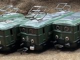 four green trains sitting next to each other on the tracks