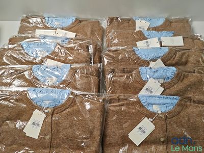 six brown shirts wrapped in plastic bags on a table