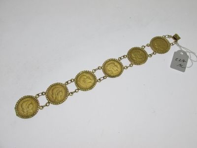 a close up of a gold bracelet on a white surface