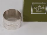 une bague en argent posée à côté d'une boîte verte sur une table
