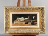 tableau représentant une nature morte avec un livre et un stylo posés sur un chevalet