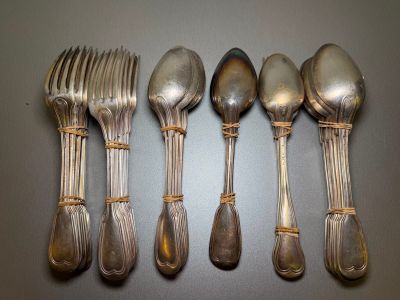 five silver spoons and six silver spoons on a table