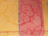 yellow and pink fabric with a paisley design on a table