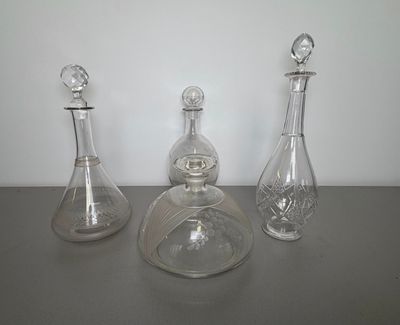 three glass decanters sitting on a table next to each other