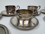 a lot of silver cups and saucers on the table