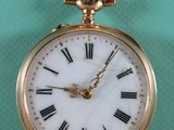 une montre de poche en or avec des chiffres romains sur le cadran