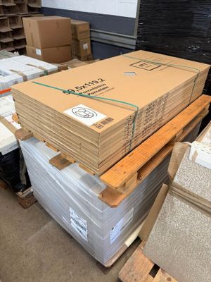 a large stack of boxes and pallets in a warehouse