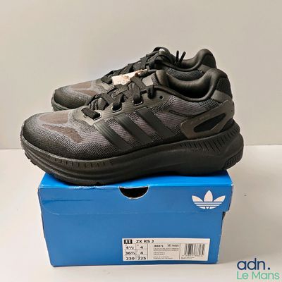 Chaussures de course adidas pour homme, dans une boîte posée sur une surface blanche