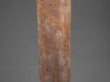 an old wooden piece of wood sitting on top of a gray surface
