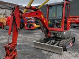 the back end of a red excavator parked in a parking lot
