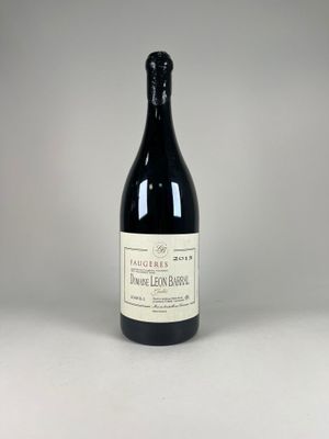 a bottle of wine sitting on top of a white table