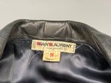un gros plan d'une veste en cuir noir sur laquelle figure une étiquette