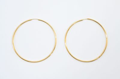 une paire de boucles d'oreilles en or sur fond blanc