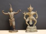 deux statues en bronze représentant un homme et une femme, posées sur un rocher
