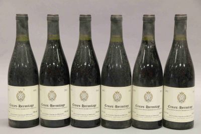 six bouteilles de vin sont alignées sur une table