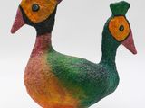 a colorful bird that is standing on a wooden stand