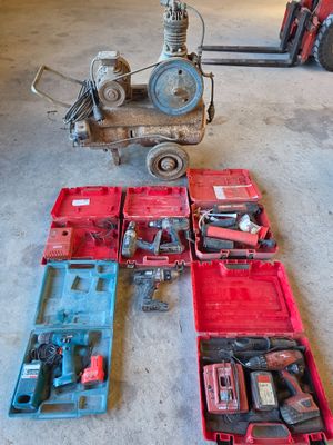 un tas d'outils posé par terre à côté d'un chariot élévateur