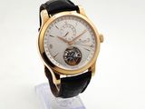 a gold wrist watch with a black leather strap