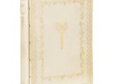 un vieux livre orné d'une croix, posé sur une surface blanche