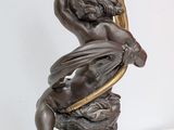 an image of a statue of a man holding a bird on top of a table