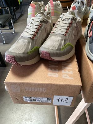 two pairs of shoes are on a cardboard box in a store