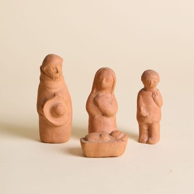 trois figurines en argile représentant une femme, un homme et un enfant