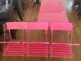 une table et des chaises roses au milieu d'une pièce