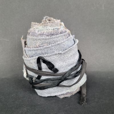 a stack of jeans wrapped in black and white ribbon