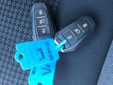 a car key with a tag attached to it sitting on a seat