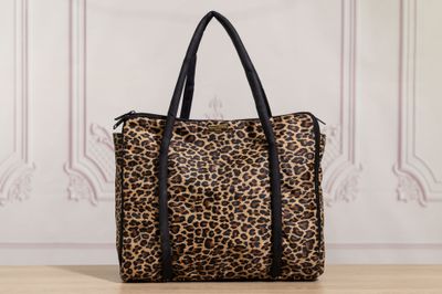 a leopard print handbag sitting on top of a wooden table