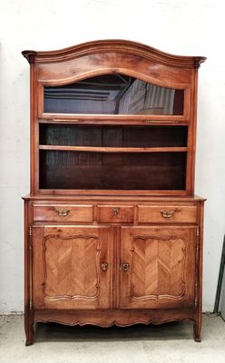 une armoire en bois surmontée d'un miroir, placée à côté d'une chaise