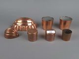 several different types of copper pipes and fittings on a gray surface