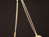 un collier plaqué or orné d'un cœur rose