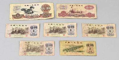 Plusieurs anciens billets de banque chinois sont exposés sur une table