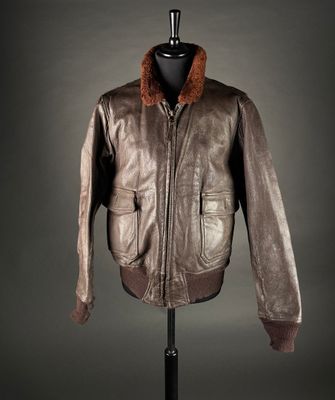 une veste en cuir marron à col en fourrure, posée sur un mannequin
