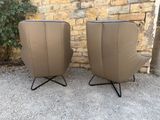 pair of mid - century modern lounge chairs in leather and metal