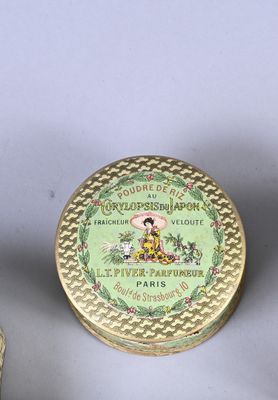 two small tins of perfume sitting next to each other on a table