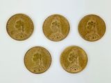 four gold coins are arranged in a row on a white surface