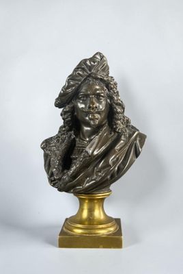 un buste en bronze représentant un homme coiffé d'un chapeau, posé sur un socle