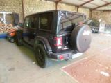 a black jeep parked inside of a building with a tire rack