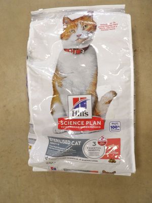 un chat assis sur un sac de nourriture