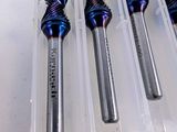 four pieces of drill bits in a plastic container on a table